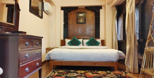 ein Schlafzimmer mit einem Bett mit einer Kommode und einem Fenster in der Unterkunft Halyo suite room Greentara Heritage Home by Tranquil home in Pātan