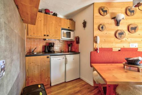 une cuisine avec des armoires en bois et une table en bois dans l'établissement Résidence Quartier Falaise - maeva Home - Appartement 2 Pièces 5 Personnes au pied des pistes - Sélection - super Home MAE-1931, à Avoriaz