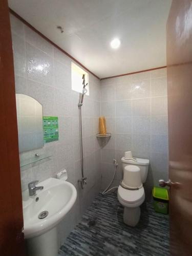 a bathroom with a white toilet and a sink at Beach Front Calatagan Apartelle in Calatagan