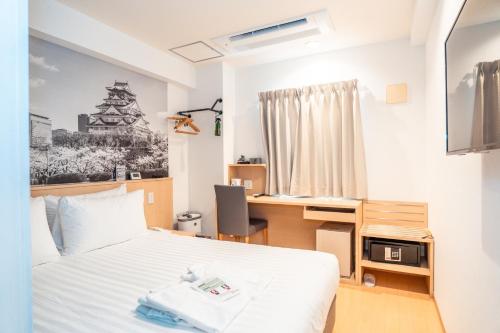 a bedroom with a bed and a desk with a computer at Travelodge Honmachi Osaka in Osaka