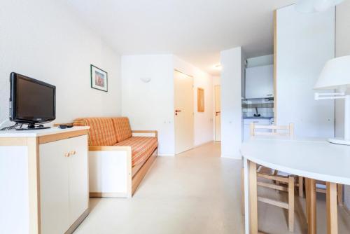 un salon avec un canapé et une télévision dans l'établissement Résidence L'Eyssina - maeva Home - Studio 3 Personnes - Budget MAE-1949, à Vars