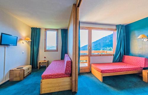 une chambre d'hôtel avec deux lits et une fenêtre dans l'établissement Quartier Crève Cœur - maeva Home - Studio 4 Personnes Sélection MAE-2006, à Valmorel