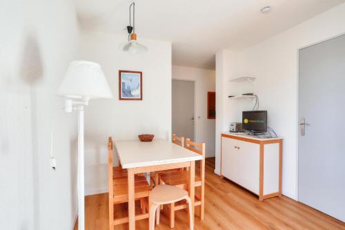 une cuisine et une salle à manger avec une table et des chaises dans l'établissement Résidence L'Eyssina - maeva Home - Appartement 3 Pièces 6 Personnes Prestige MAE-3088, à Vars