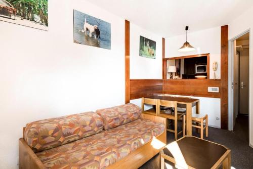 un salon avec un canapé et une table dans l'établissement Résidence Les Fontaines Blanches - maeva Home - 2 Pièces 5 Personnes Budget MAE-3633, à Morzine
