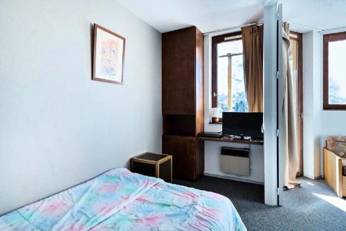 une chambre avec un lit et un bureau avec un ordinateur portable dans l'établissement Résidence Les Fontaines Blanches - maeva Home - 2 Pièces 5 Personnes Budget MAE-3633, à Morzine