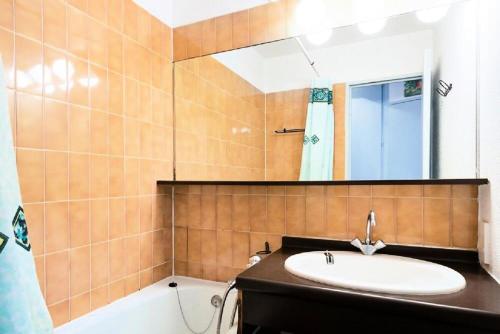 une salle de bain avec un lavabo, un miroir et une baignoire dans l'établissement Résidence Les Fontaines Blanches - maeva Home - 2 Pièces 5 Personnes Budget MAE-3633, à Morzine