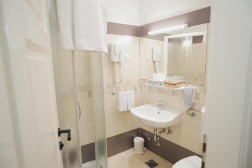 een badkamer met een wastafel, een toilet en een spiegel bij Sobe Bernarda in Varaždinske Toplice
