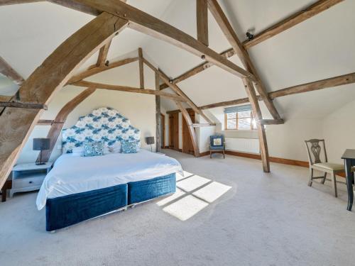 una camera con letto in una stanza con travi in legno di The Chestnuts a Tenbury