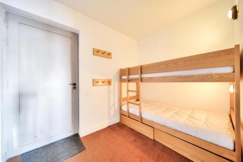 1 Schlafzimmer mit 2 Etagenbetten und einer Tür in der Unterkunft Résidence La Marelle et Le Rami - maeva Home - Studio 4 Personnes - Sélecti 00 in La Plagne Tarentaise