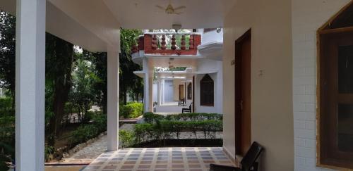 uma entrada para uma casa branca com uma varanda em The Baagh Jungle Resort em Khajurāho