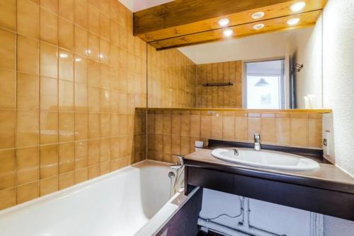une salle de bain avec un lavabo et une baignoire dans l'établissement Résidence Les Fontaines Blanches - maeva Home - 2 Pièces 4 Personnes Sélection MAE-5573, à Morzine
