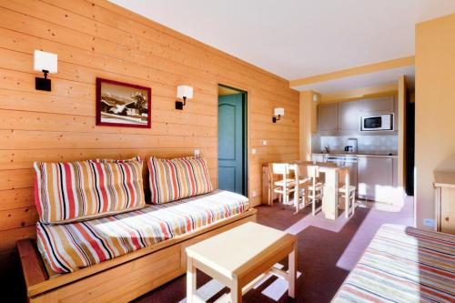un salon avec un canapé et une cuisine dans l'établissement Résidence La Marelle et Le Rami - maeva Home - 2 Pièces 5 Personnes Sélection MAE-6534, à La Plagne Tarentaise
