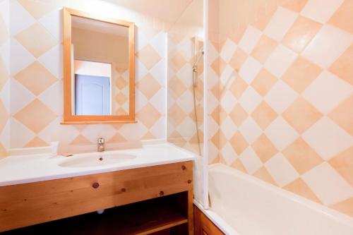 une salle de bain avec un lavabo, une baignoire et un miroir dans l'établissement Résidence La Marelle et Le Rami - maeva Home - 2 Pièces 5 Personnes Sélection MAE-6534, à La Plagne Tarentaise