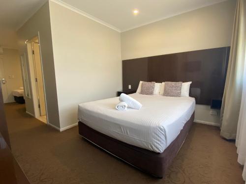 a bedroom with a bed with two towels on it at Timbertown Motel in Wauchope