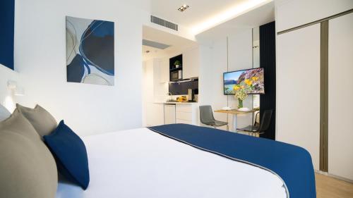 a bedroom with a white bed and a desk at Stile Suite Marine Hotel in Antalya