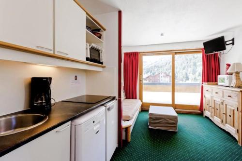 une cuisine avec un évier et un plan de travail dans l'établissement Résidence Les Sentiers du Tueda - maeva Home - 2 Pièces 4 Personnes Confort MAE-4845, à Les Allues