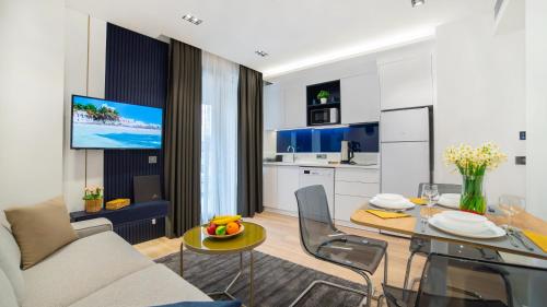 ein Wohnzimmer mit einem Sofa und einem Tisch sowie eine Küche in der Unterkunft Stile Suite Marine Hotel in Antalya