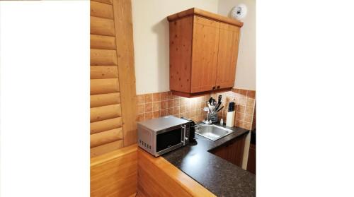 une cuisine avec un évier et un micro-ondes dans l'établissement Résidence Les Arcs 1950 Le Village - maeva Home - 3 Pièces 6 Personnes Sélection MAE-4294, à Bourg-Saint-Maurice