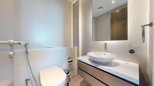 a bathroom with a sink and a toilet and a mirror at Primestay - 2BR Damac Prive in Business Bay in Dubai