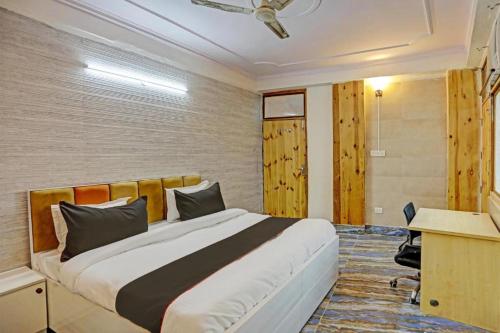 a bedroom with a large bed and a desk in it at Umen Hotel Sector 66 in Noida