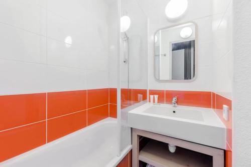 une salle de bain avec un lavabo blanc et un miroir dans l'établissement Résidence Antarès - maeva Home - 2 Pièces 4 Personnes Sélection MAE-4857, à Avoriaz