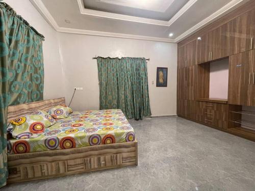 een slaapkamer met een bed en een flatscreen-tv bij 3-bedroom bungalow. Free parking on the premises. in Benin City