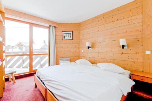 - une chambre avec un lit et une grande fenêtre dans l'établissement Résidence Le Tikal - maeva Home - 3 Pièces 6 Personnes Budget 54, à Val Thorens