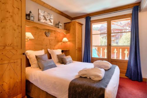 une chambre avec un lit avec deux serviettes dessus dans l'établissement Résidence Les Arcs 1950 Le Village - maeva Home - 3 Pièces 6 Personnes Prestige - Prince des Cîmes MAE-5948, à Bourg-Saint-Maurice