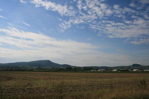 a field with a blue sky and mountains in the background at Fontana Vendégház in Tát