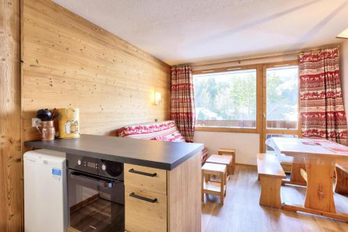une cuisine et un salon avec une table et une salle à manger dans l'établissement Quartier Crève Cœur - maeva Home - 2 Pièces 4 Personnes Confort MAE-9058, à Valmorel
