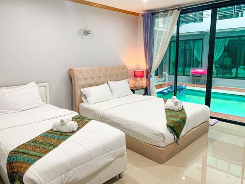 a bedroom with two beds and a swimming pool at Three Bridges Hotel in Nan