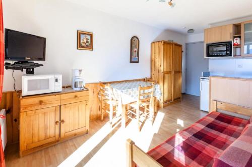 Il comprend un salon avec une cuisine et une table à manger. dans l'établissement Appartement 4 pers. au pied des pistes - maeva Home - 2 pièces 4 Personnes Sélection MAE-9349, à L'Alpe-d'Huez