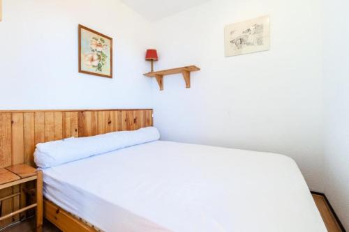 ein kleines Schlafzimmer mit einem Bett und einem Kreuz an der Wand in der Unterkunft Appartement 4 pers. au pied des pistes - Maeva Particuliers 69755 in L'Alpe-d'Huez