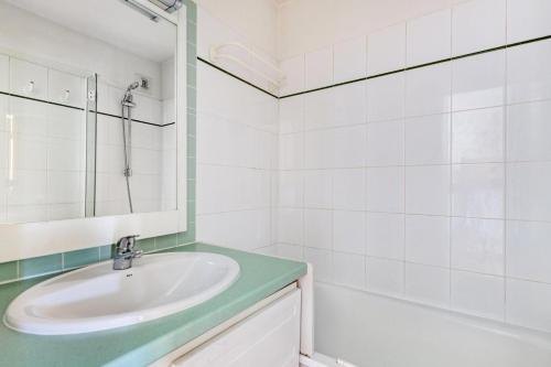 La salle de bains blanche est pourvue d'un lavabo et d'une baignoire. dans l'établissement Résidence Le Montana - maeva Home - Studio 4 Personnes Sélection MAE-9410, à La Mongie
