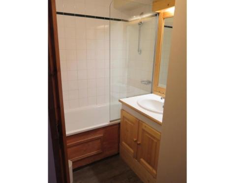La salle de bains est pourvue d'une baignoire, d'un lavabo et d'une douche. dans l'établissement Résidence Les Valmonts - maeva Home - 2 pièces 4 Personnes Sélection 71, à Saint-Martin-de-Belleville
