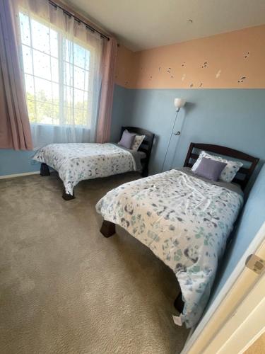 a bedroom with two beds and a window at Spacious and modern home near Temecula wineries in Murrieta