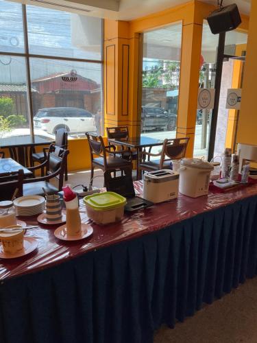 Sungai Kolok的住宿－INTERTOWER HOTEL (SHA)，餐厅里一张长桌,上面有食物