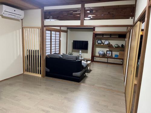 a living room with a couch and a television at 富士山世界文化遺産三保松原久能山東照宮日本観光地第一日本平体験日本文化貸切民泊韶光 in Shizuoka