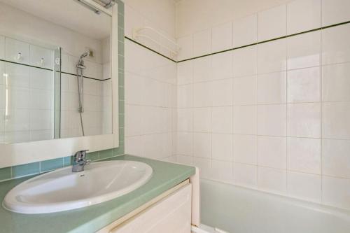 une salle de bain avec un lavabo, un miroir et une baignoire dans l'établissement Résidence Le Montana - maeva Home - 2 pièces 6 Personnes Confort MAE-9429, à La Mongie
