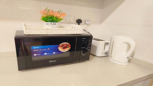 a microwave on a counter with a basket on top of it at Mutiara Melaka Beach Resort by Glex in Tangga Batu