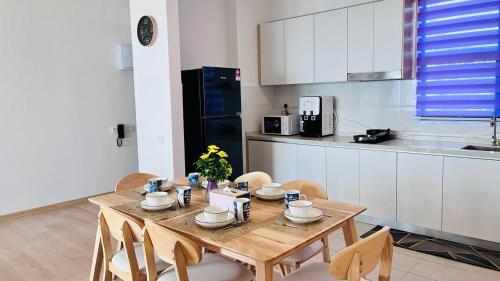 a kitchen with a wooden table and chairs in a kitchen at Mutiara Melaka Beach Resort by Glex in Tangga Batu
