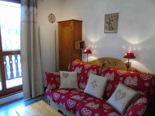 - un salon avec un canapé rouge et des oreillers dans l'établissement Résidence Vita Parc - Studio pour 4 Personnes MAE-8514, à Modane