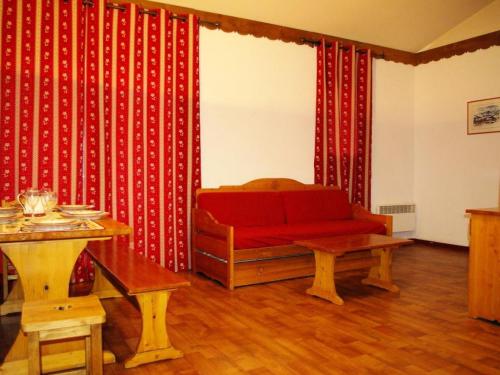 un salon avec un canapé rouge et une table dans l'établissement Duplex pers. proche des pistes - Pièces 95, à Modane