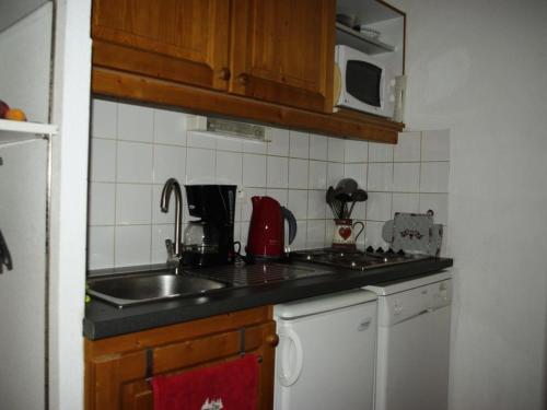 une cuisine avec un évier et un plan de travail dans l'établissement Duplex pers. proche des pistes - Pièces 95, à Modane