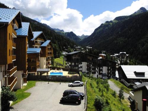 une ville avec des voitures garées dans un parking avec des montagnes dans l'établissement Duplex pers. proche des pistes - Pièces 95, à Modane