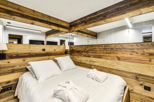 - une chambre avec un grand lit blanc et des murs en bois dans l'établissement Résidence Les Arcs 1950 Le Village - maeva Home - Appartement 2 Pièces 6 Personnes - Prestige MAE-0444, à Bourg-Saint-Maurice