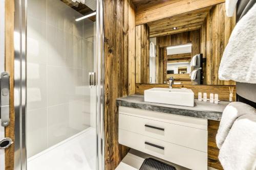 une salle de bain avec un lavabo et une douche dans l'établissement Résidence Les Arcs 1950 Le Village - maeva Home - Appartement 2 Pièces 6 Personnes - Prestige MAE-0444, à Bourg-Saint-Maurice