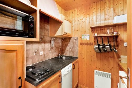 une cuisine avec un évier et un micro-ondes dans l'établissement Chalet le Séchet - maeva Home - 2 Pièces 4 personnes Confort MAE-0619, à Bellentre