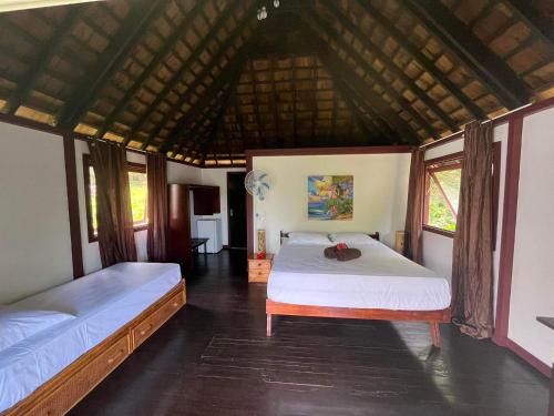 um quarto com duas camas num quarto em Pension Hibiscus Taha'a em Vaitoare