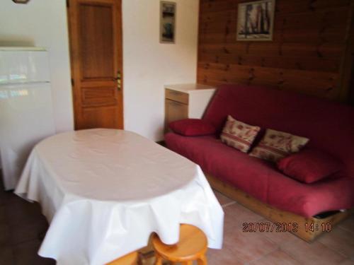 un salon avec un canapé rouge et une table dans l'établissement Appartement 6 pers. avec vue montagne - 3 pièces 5 personnes MAE-0672, à Saint-Sorlin-dʼArves